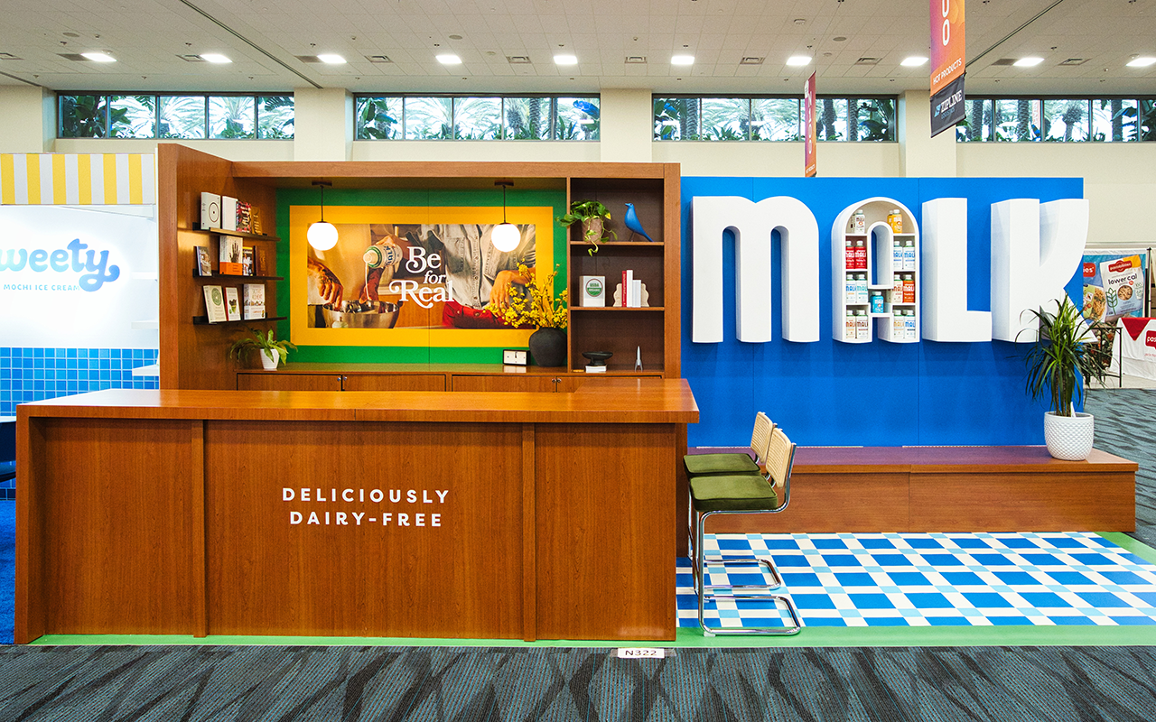MALK Organics Expo West booth in North Hall with clean wooden design, sampling counter, and large logo display