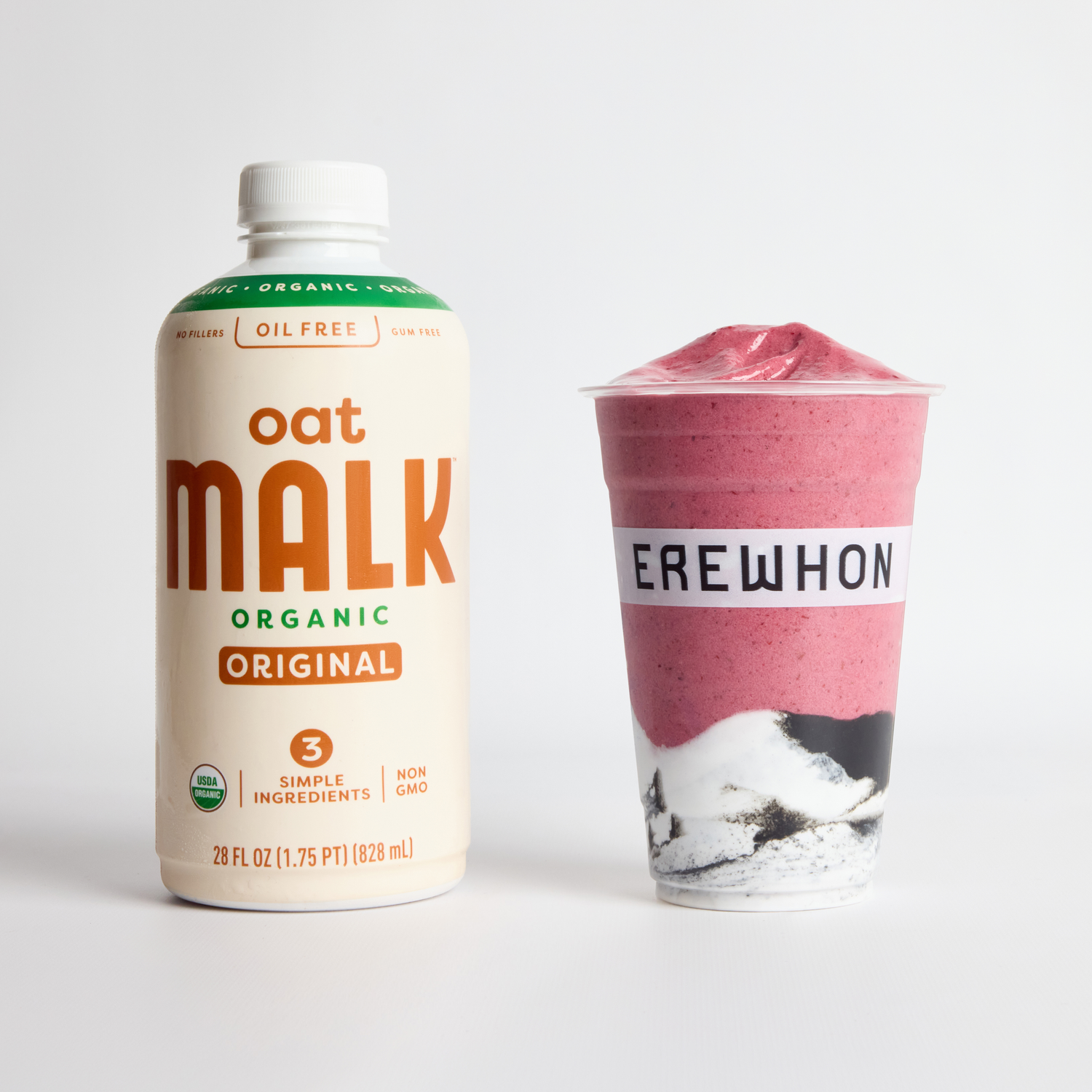 MALK Organic Original Oat Milk bottle next to the Laufey x Erewhon Madwoman Smoothie, a vibrant pink berry blend served in an Erewhon cup