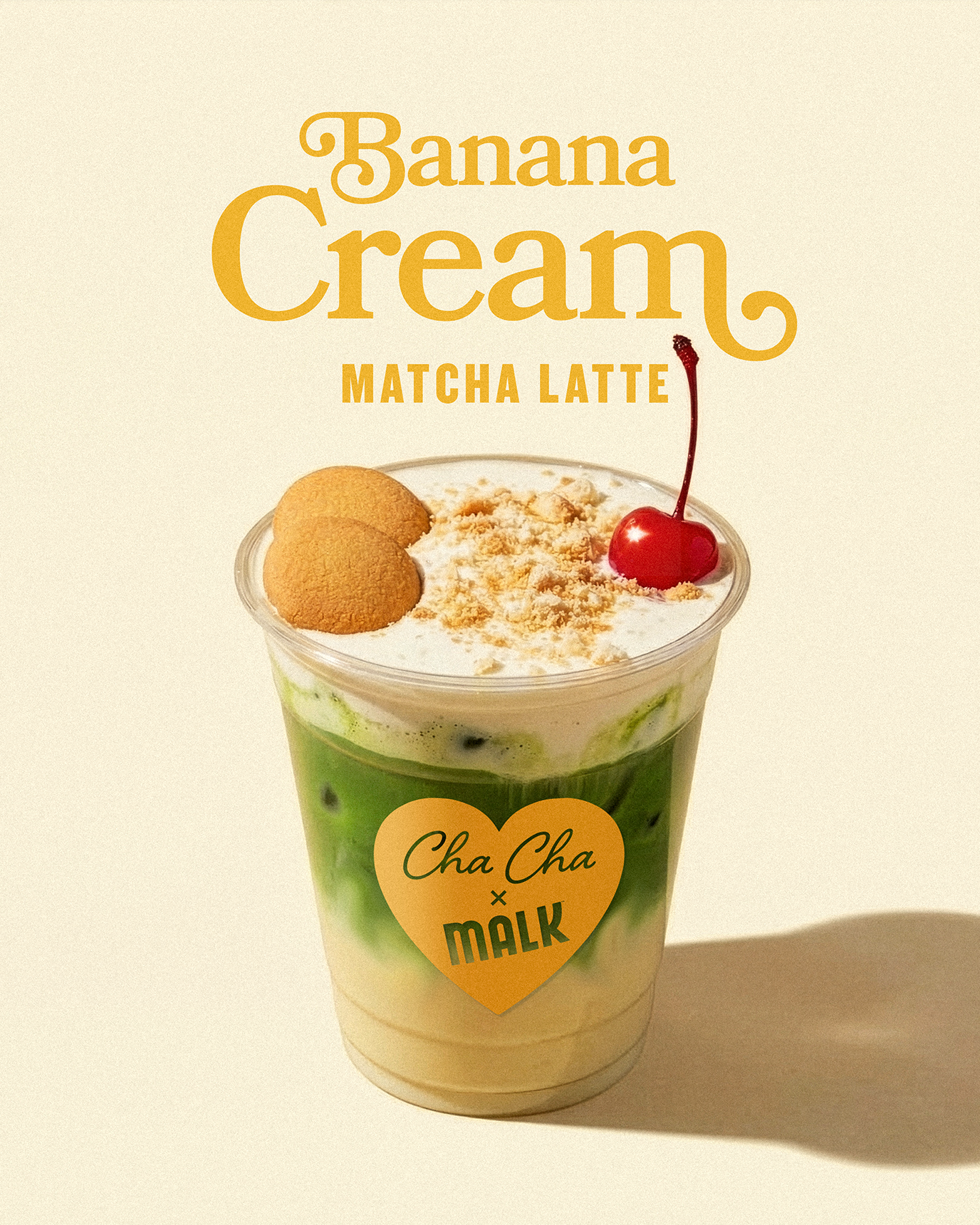 Banana cream matcha latte made with MALK coconut creamer topped with non-dairy foam, wafers, and cherry