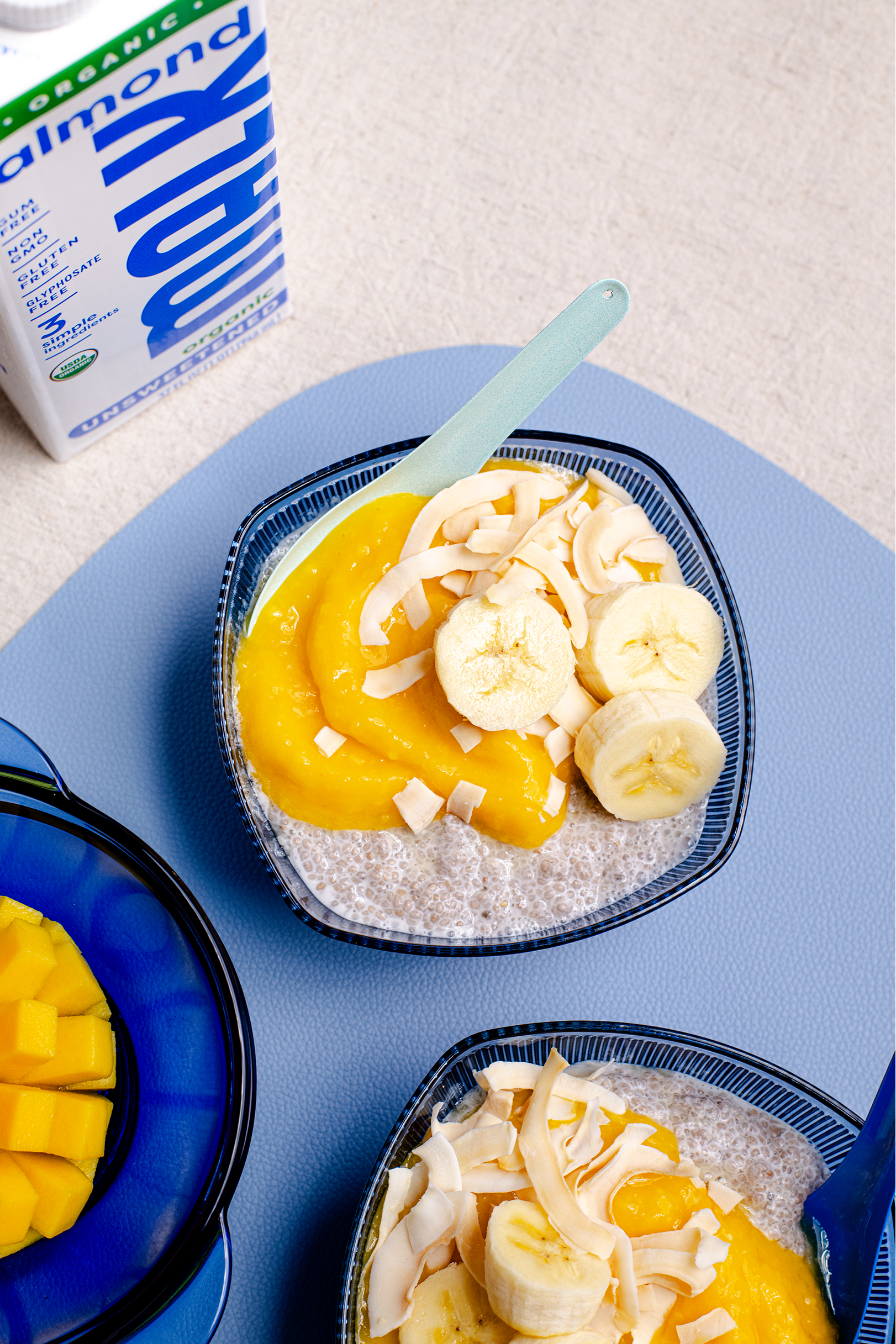 Mango chia pudding made with MALK Unsweetened Almond Milk, layered with fresh mango puree and topped with fruit