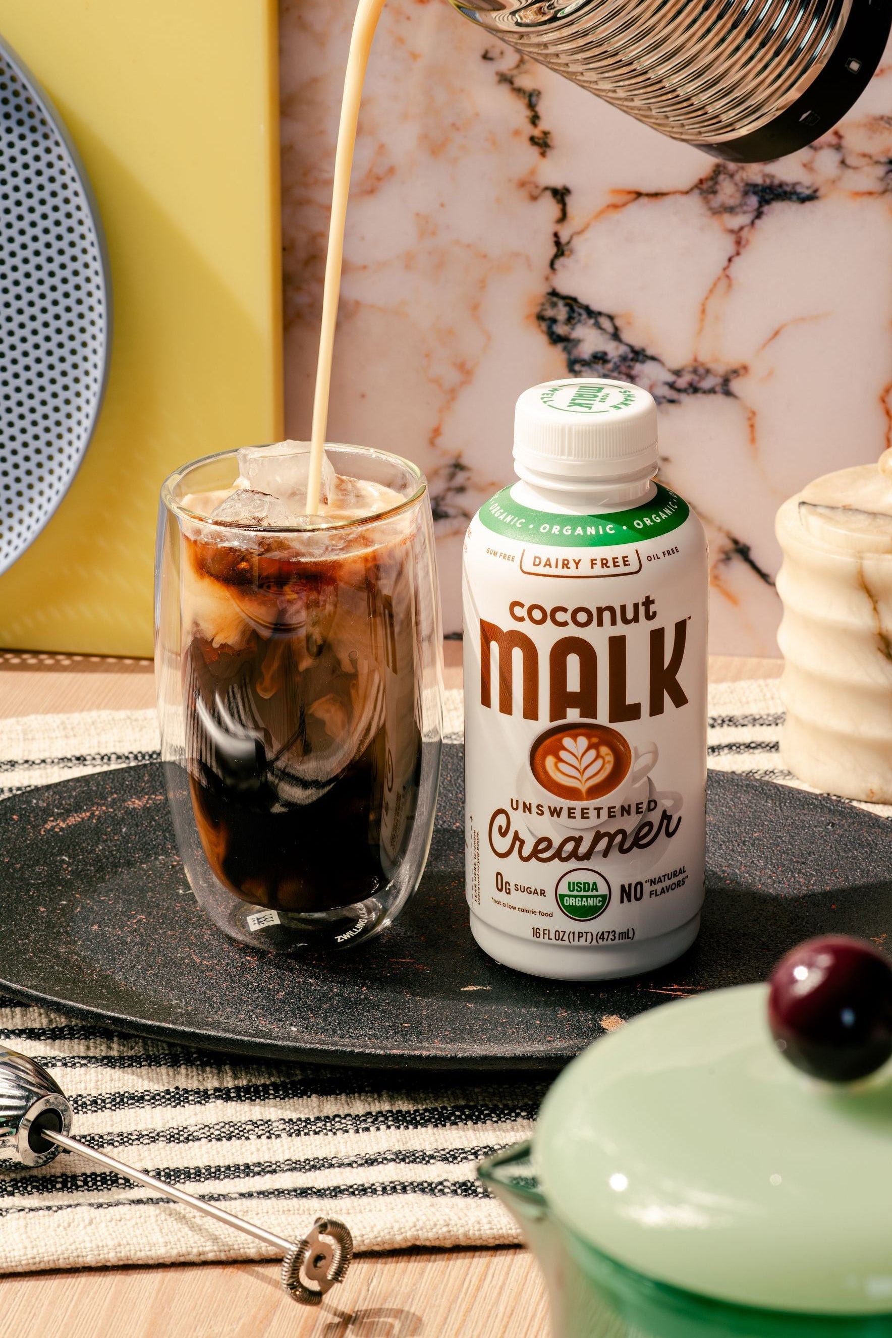 MALK Organic Unsweetened Coconut Creamer poured into iced cold brew to make a salted caramel cream cold brew.