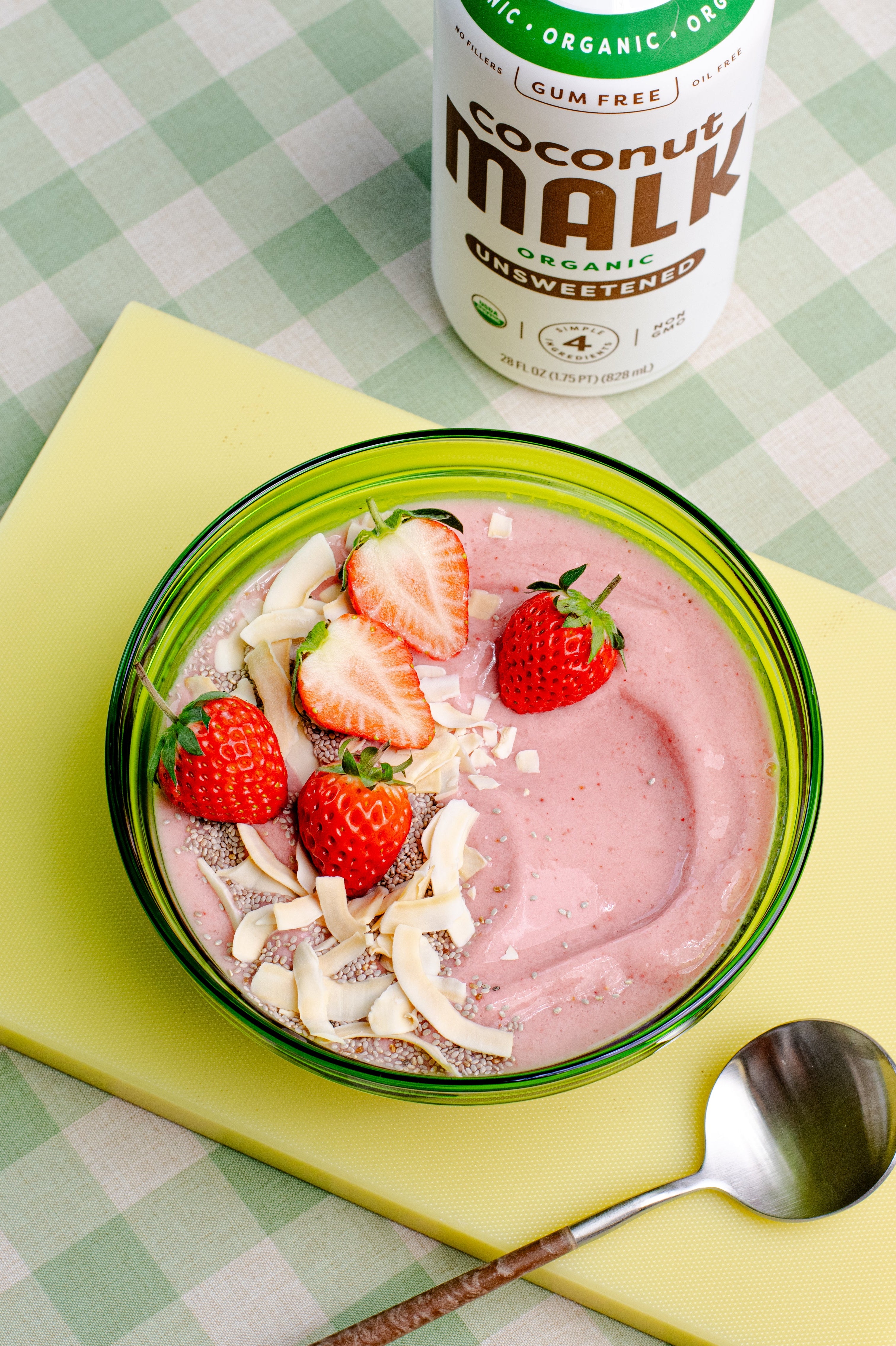Strawberry banana smoothie bowl made with MALK Unsweetened Coconut Milk, topped with fresh strawberries and coconut flakes.