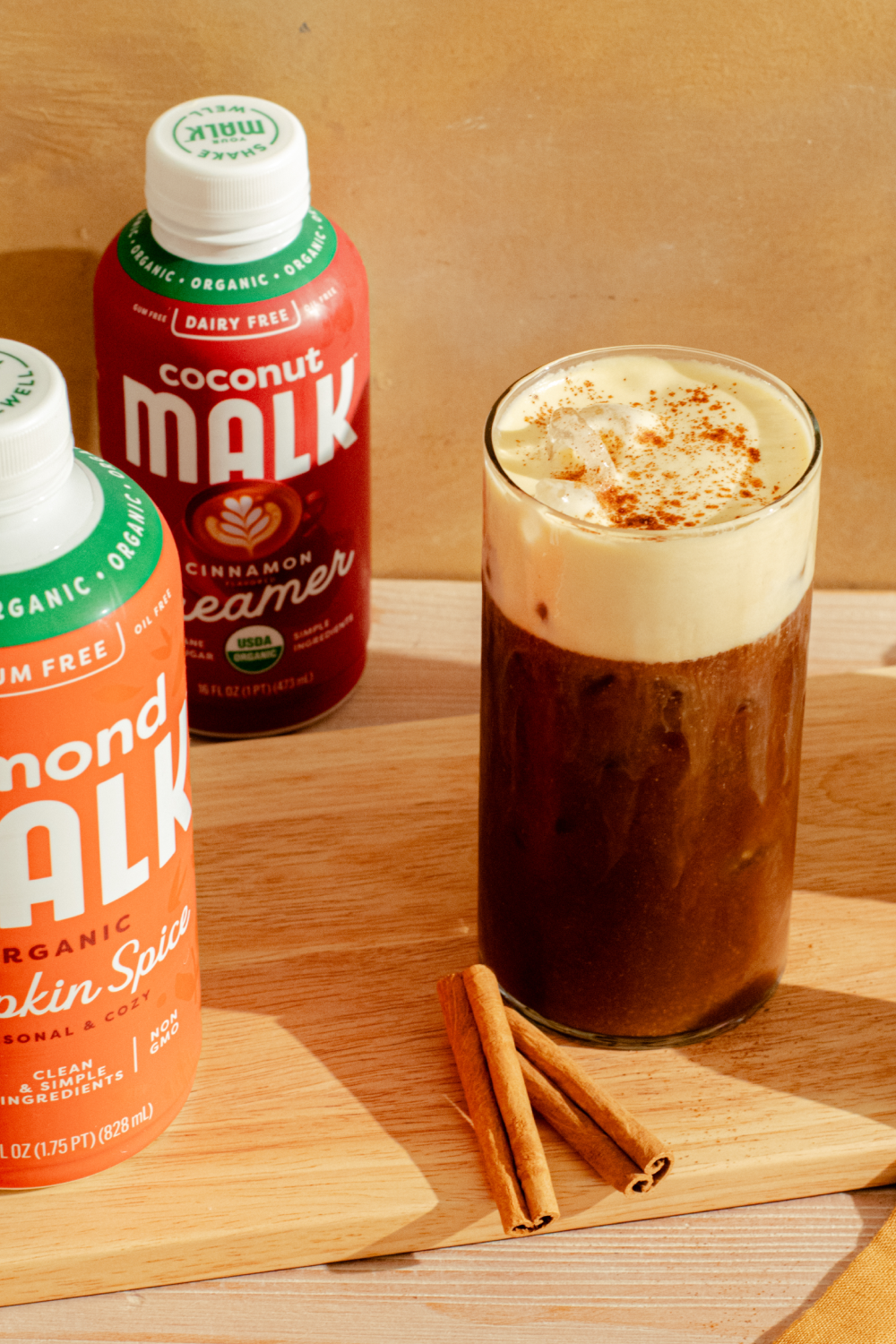 MALK Pumpkin Spice Cream Cold Brew with a bottle of Pumpkin Spice MALK and MALK Cinnamon Creamer