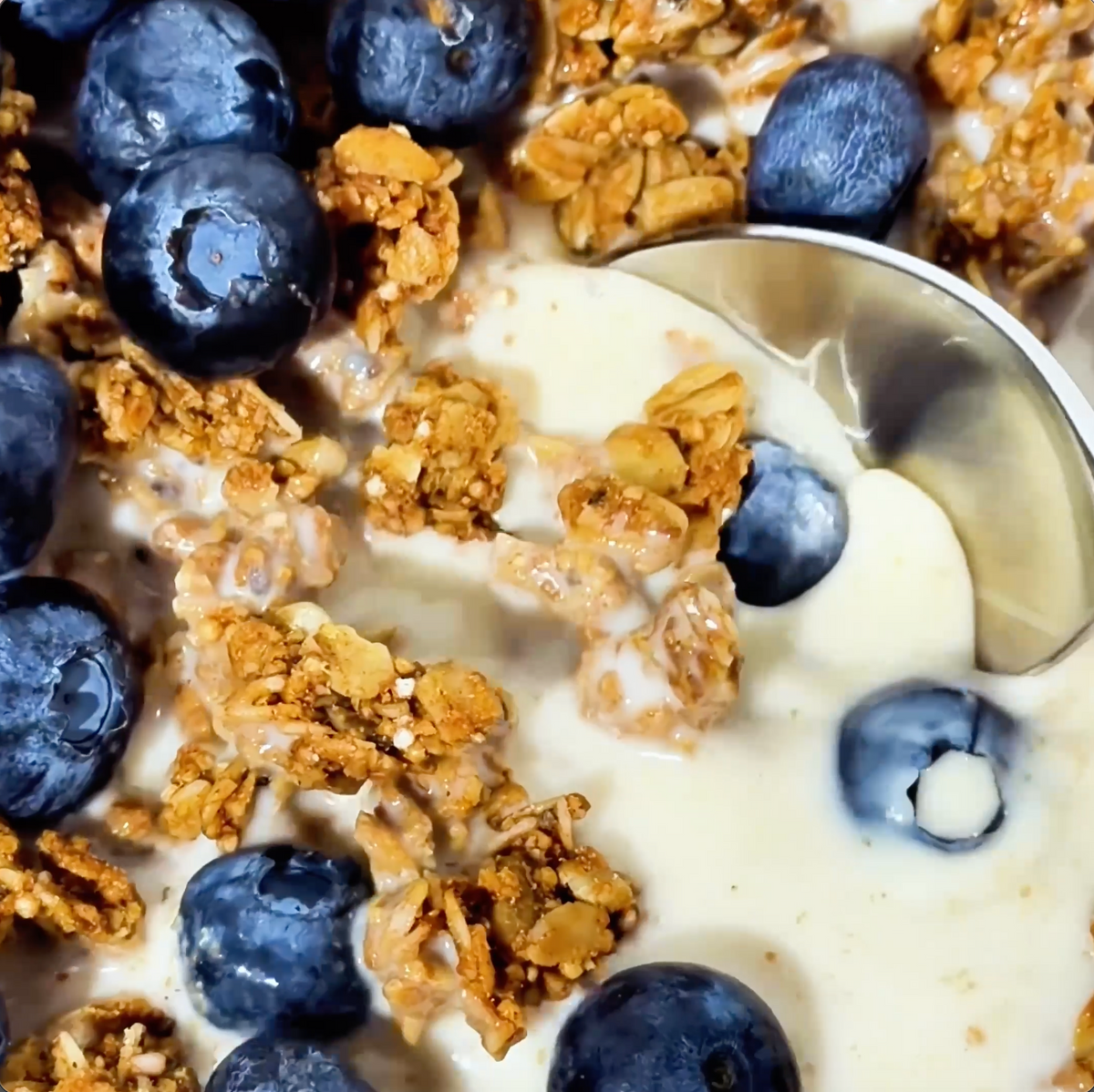 MALK Vanilla Almond Milk being poured into a bowl of cereal with blueberries