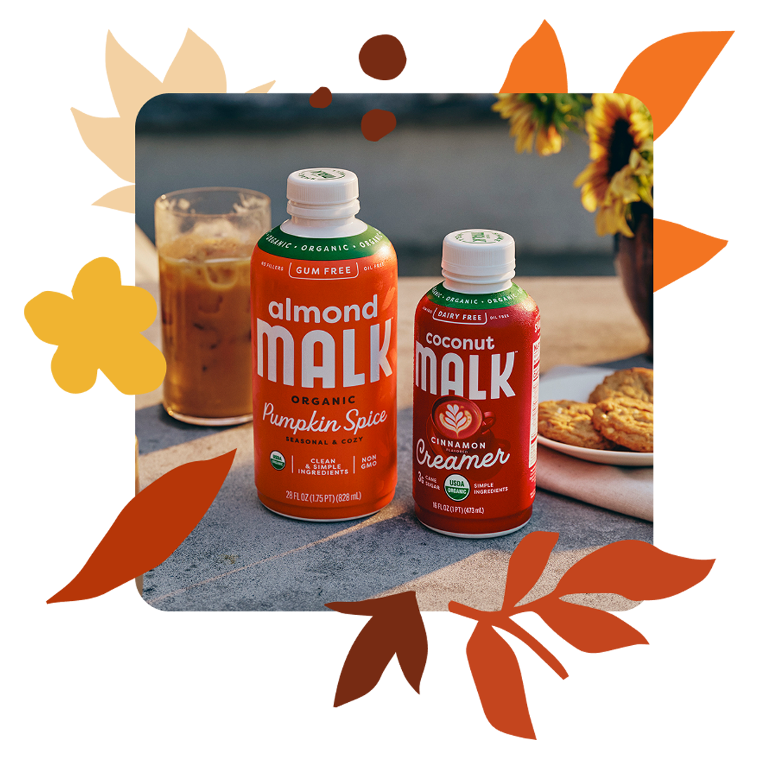 Bottles of MALK Cinnamon Creamer and Pumpkin Spice MALK side by side with a latte in the background 